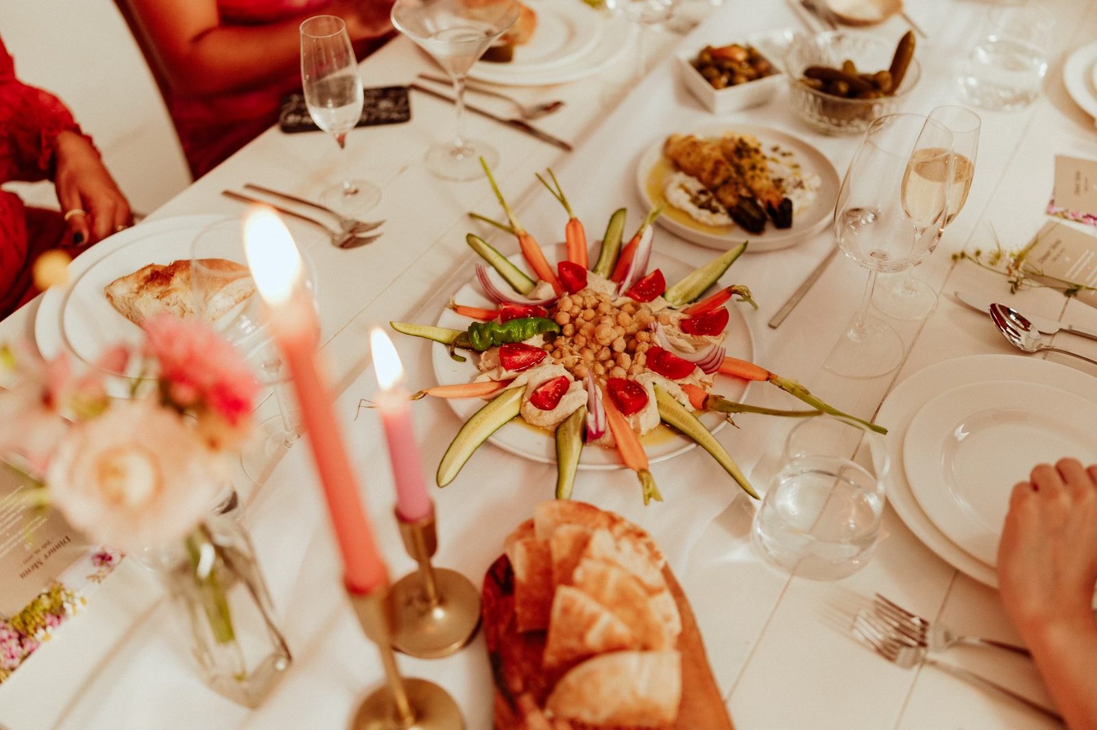 A family-style table set with mezze and candles